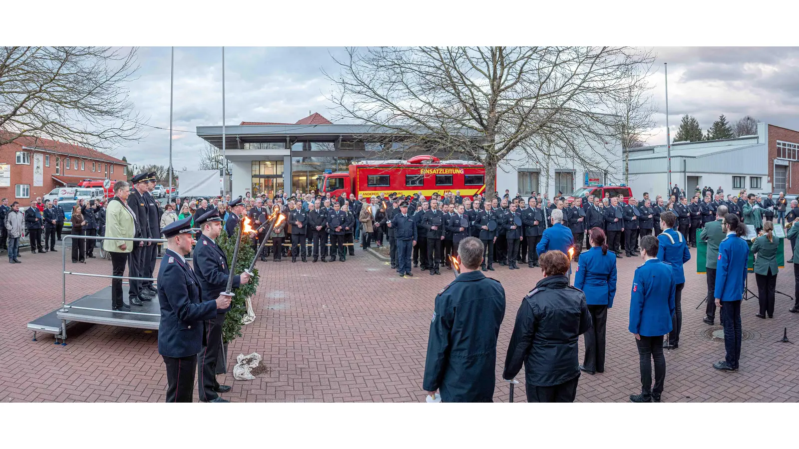 Auf dem Vorplatz des Sägewerk in Lauenau fand für den Kreisbrandmeister Klaus-Peter Grote ein großer Zapfenstreich statt, neben ihn auf dem Podest seine Frau Bärbel Grote und sein Nachfolger Joachim Muth (Foto: wk)