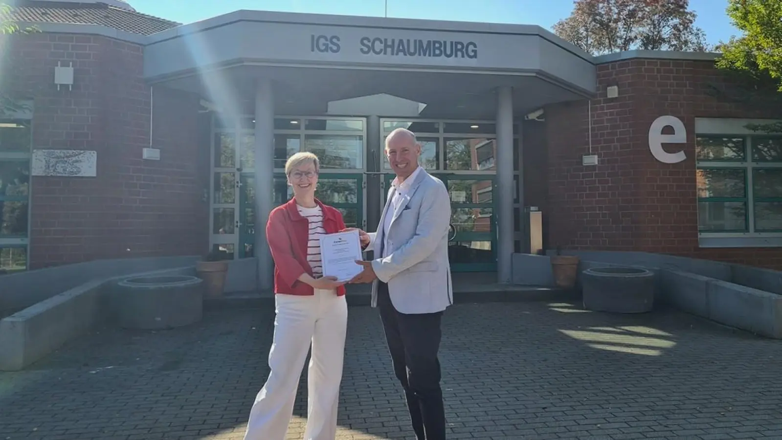 Schulleiterin Dr. Astrid Budwach und Möbel Heinrich Personalleiter Martin Sondermann präsentieren das Förderzertifikat für den Schüler-Ferienpass. (Foto: privat)
