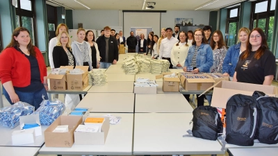 Viele Hände, schnelles Ende. Schülerinnen und Schüler angehender Industriekaufleute packen 280 Rucksäcke für Schulabgänger. (Foto: ste)