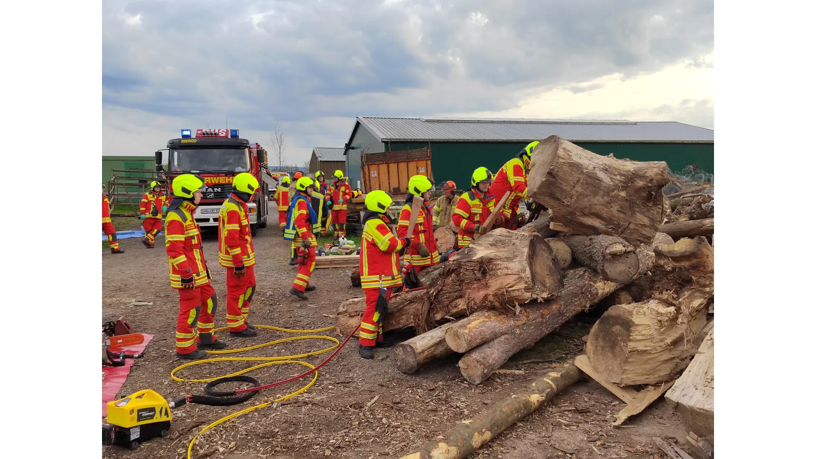 Die Feuerwehrleute trainieren während der Übung, eingeklemmte Personen unter schweren Holzstämmen zu befreien.  (Foto: Adrian Lesser Team Presse)