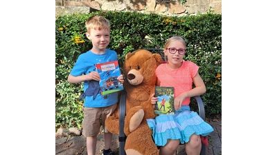 Der sechsjährige Jonas war begeistert über ein Erstlesebuch zum Thema Feuerwehr. Isabel (9) freute sich über „Hanna, Hüterin des Waldes“, in dem ein Mädchen gemeinsam mit einem frechen Wiesel die Waldtiere beschützt. Zur Erinnerung wurde ein gemeinsames Foto mit dem Honigbär gemacht.  (Foto: privat)
