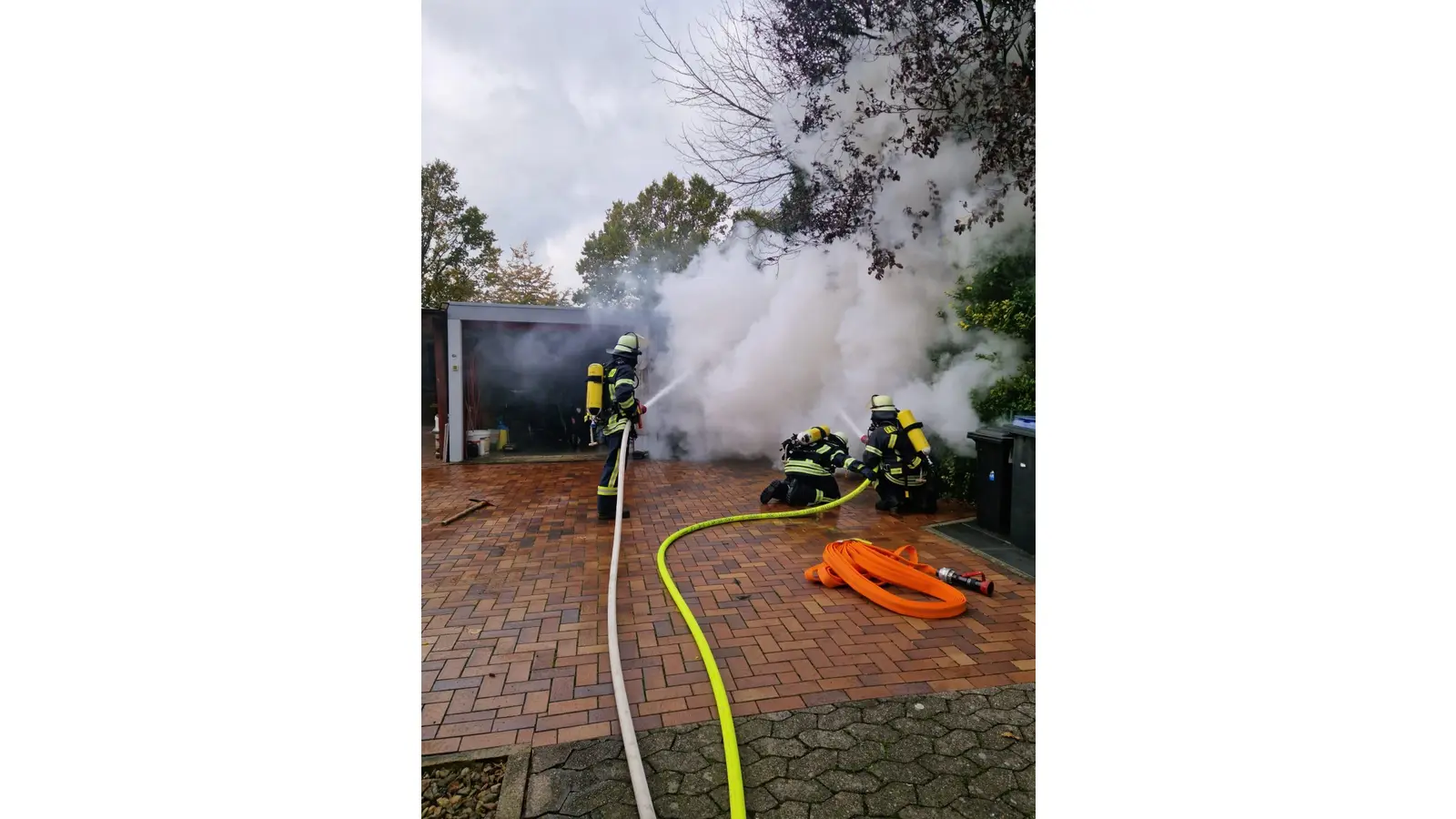 Die Feuerwehrleute gehen gegen den Brand in der Garage vor. (Foto: Borchers, Bastian)