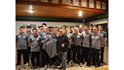 Bei der Übergabe im Kreise der Mannschaft: Spartenleiter Fußball, Axel Bommert (li.), nimmt ein Shirt von Thomas Silbermann entgegen. (Foto: privat)