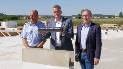 Samtgemeindebürgermeister Mike Schmidt setzt gemeinsam mit Ortsbrandmeister Lars Hecht (li.) und Uwe Brinkmann, Planungsbüro, den Grundstein mit Zeitkapsel. (Foto: gk)