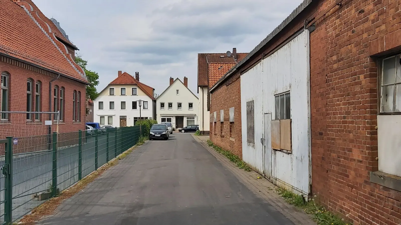 Gleich gegenüber der neuen Mehrzweckhalle (li.) der Schule, liegt das Grundstück Im Jagdgarten 2 (re.) für einen möglichen Umbau zu einer KiTa-Einrichtung. (Foto: gk)