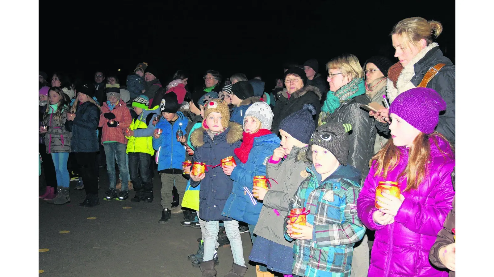 Grundschüler tragen singend Lichter in die Welt und auf den Schulhof in Evesen (Foto: ha)