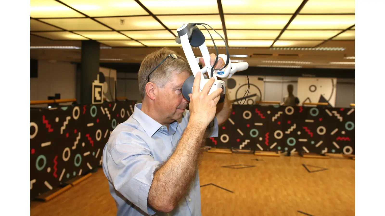 Jochen Kreft streift eine der VR-Brillen über, die es ermöglichen in die digitalen Erlebniswelten einzutauchen.  (Foto: bb)
