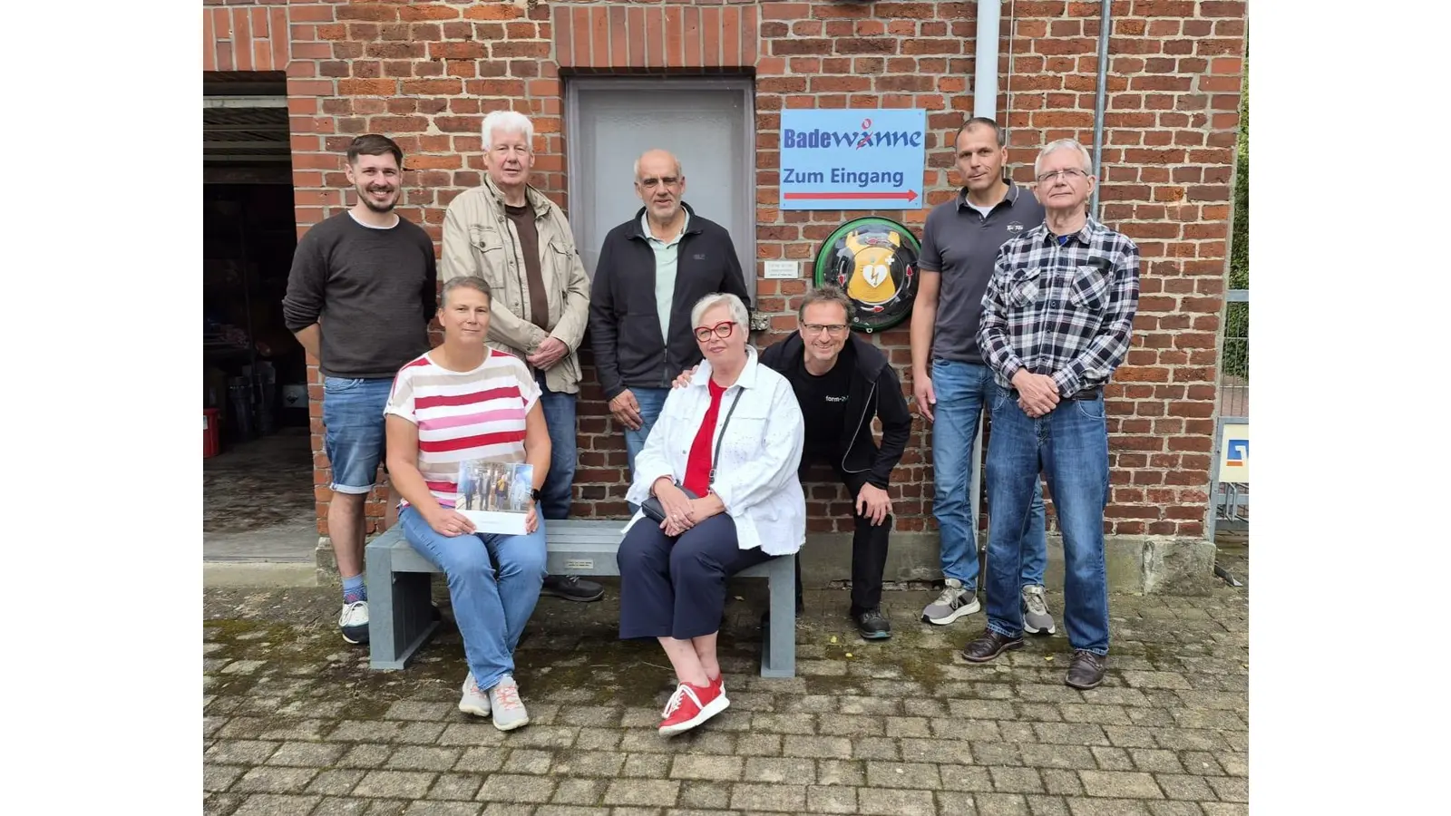 Sven Maibaum (v. li. Stehden) vom Rugby Club, Adolf Deterding, Bürgermeister Gemeinde Nordsehl, Wilhelm Eickenjäger, Bauausschuss-Vorsitzender Samtgemeinde Niedernwöhren, Ernst Dieter Pape, Dietmar Böse (Badewonne), Margit Pape (v. li, sitzend), Heide Petras sowie Uwe Staade (abgebückt) bei der Übergabe der Spende. (Foto: privat)