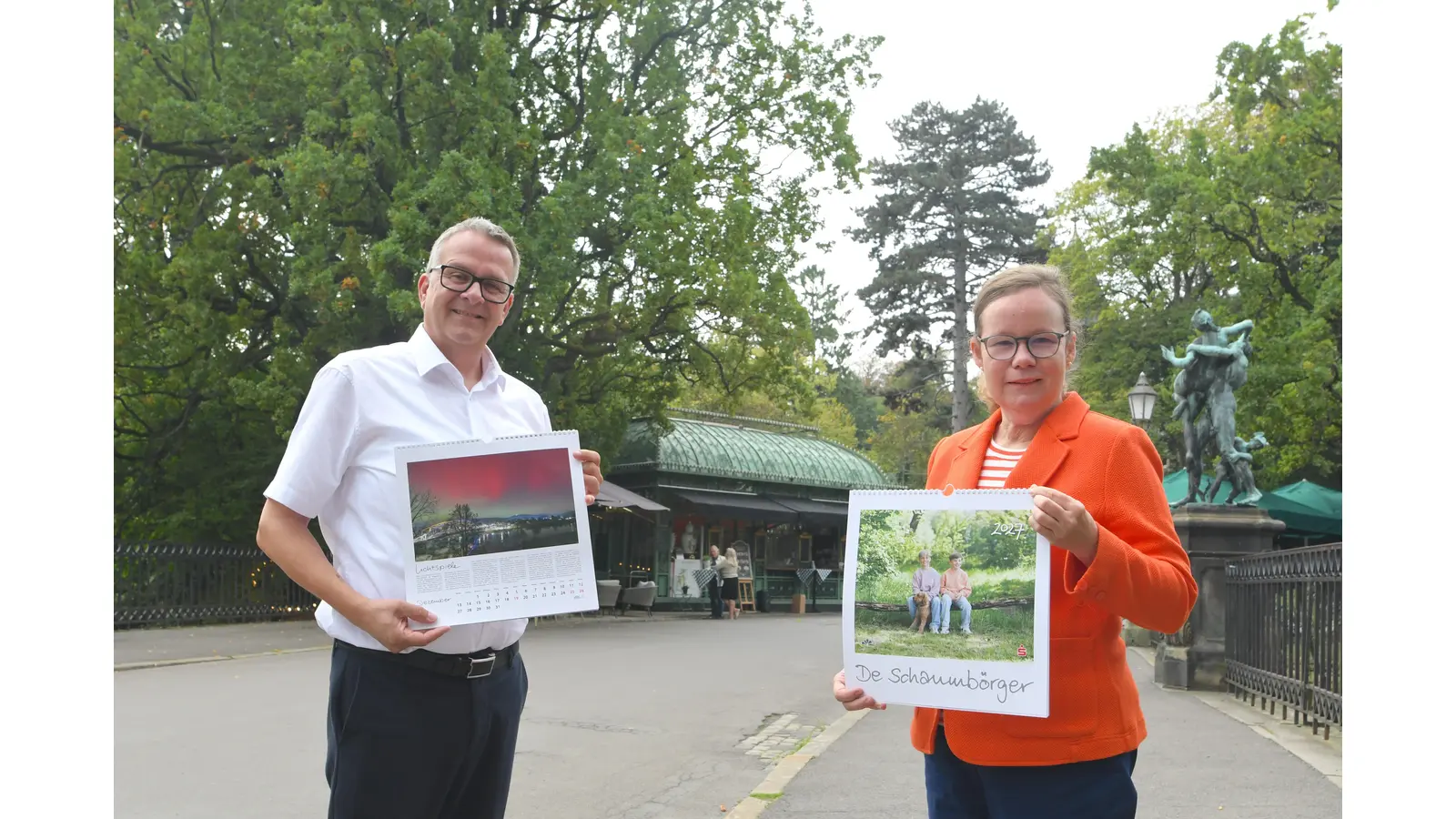 Jörg Nitsche, Leiter der Unternehmenskommunikation der Sparkasse Schaumburg, und Dr. Lu Seegers, Geschäftsführerin der Schaumburger Landschaft, bei der Vorstellung des Kalenders vor der historischen Kulisse am „Le Pavillion” des Schlosses Bückeburg. (Foto: nd)