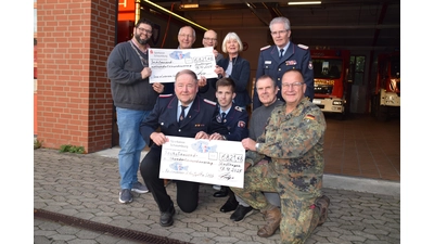 Heiko Tadge, Ingo Bölling (vorn rechts), Horst Struckmeier und Michael Angelis (hinten links) übergeben die symbolischen Schecks an den Sozialverband und die Feuerwehr. (Foto: ab)