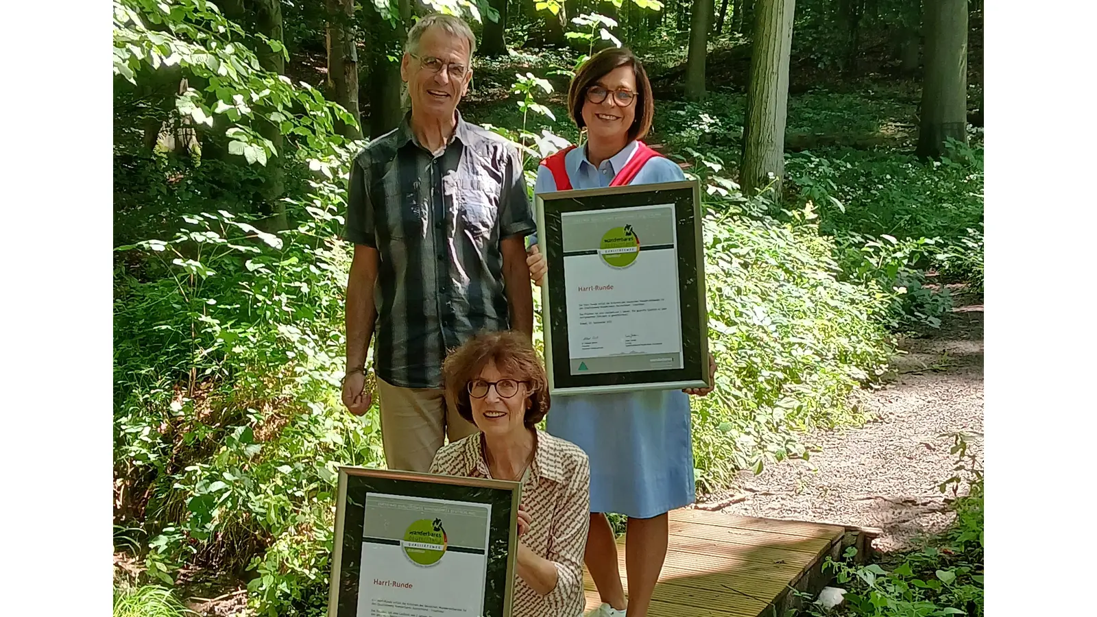 Elke Dralle von der Tourist-Info Bad Eilsen, Hans-Georg Sievers, Wanderwegemanager des Naturparks Weserbergland und Astrid Herbst-Wagner von der Tourist-Info Bückeburg freuen sich über den neuen Steg an der Harrl-Runde und die Zertifizierung des Wegs als Qualitätsweg Wanderbares Deutschland.<br> <br>  (Foto: privat)