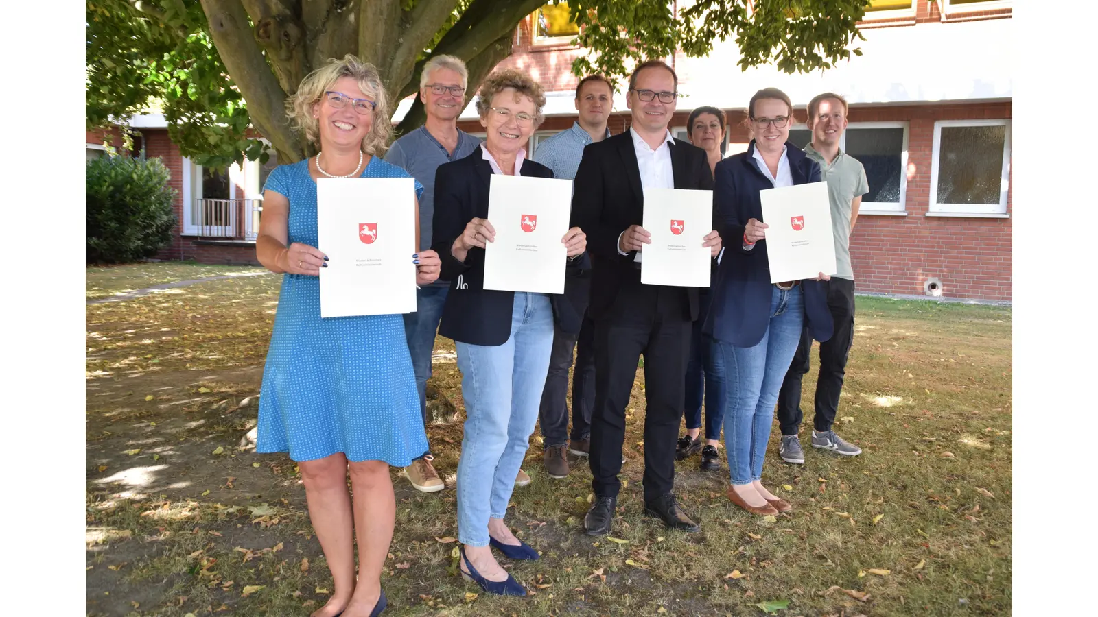 v.l.n.r.: Heike Radecke , Martin Banser, Claudia Roth, Stangneth, Kultusminister Grant-Hendrik Tonne, Iris Schmidt, Aileen Borschke, Harm Tielking mit den Förderbescheiden. (Foto: ab)