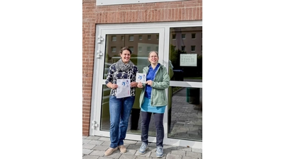 Sarah Pilhofer nimmt die Urkunde und die Plakette „Schwalbenfreundliches Haus“ von Janine Cappai vom NABU Stadthagen/Niedernwöhren entgegen. (Foto: Nabu)