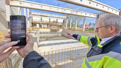 Heiko Büthe von „Constrata“ zeigt, wie der Sprungturm im 25-Meter-Becken neu angeordnet wird. (Foto: ste)