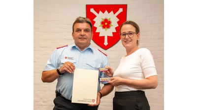 Samtgemeindebürgermeisterin Aileen Borschke (li.) übergibt Gregor Zimmermann Urkunde und neue Schulterstücke. (Foto: Privat)