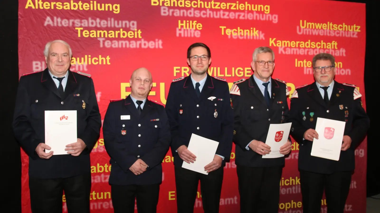 Detlef Lucks (50 Jahre Feuerwehrmitgliedschaft), Sebastian Fröhlich und Jonas Ammerschubert (beide 25 Jahre aktiver Dienst im Feuerlöschwesen), Stefan Fuhrich und Frank vom Bruch (50 Jahre Mitgliedschaft in der Feuerwehrmusik) werden für ihre langjährige Treue ausgezeichnet. (Foto: bb)