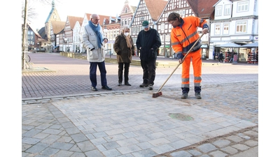 Das Bauhof-Team verlegt die neue Musterfläche auf dem Marktplatz unter den Augen interessierter Bürger. (Foto: Borchers, Bastian)