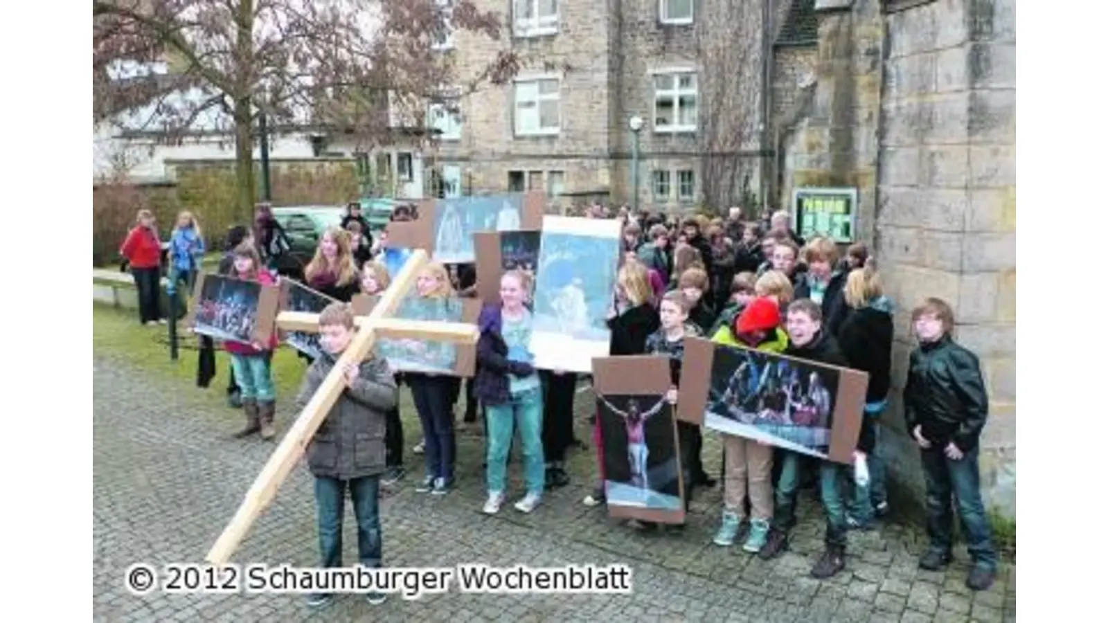 Mit Holzkreuz und Fotos begeben sich Jugendliche in Rinteln auf den Kreuzweg (Foto: km)