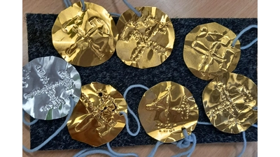 Die Kinder prickeln ihre eigene Fahrmarke aus Blechfolie. (Foto: BBMK gGmbH / Markus Miller)