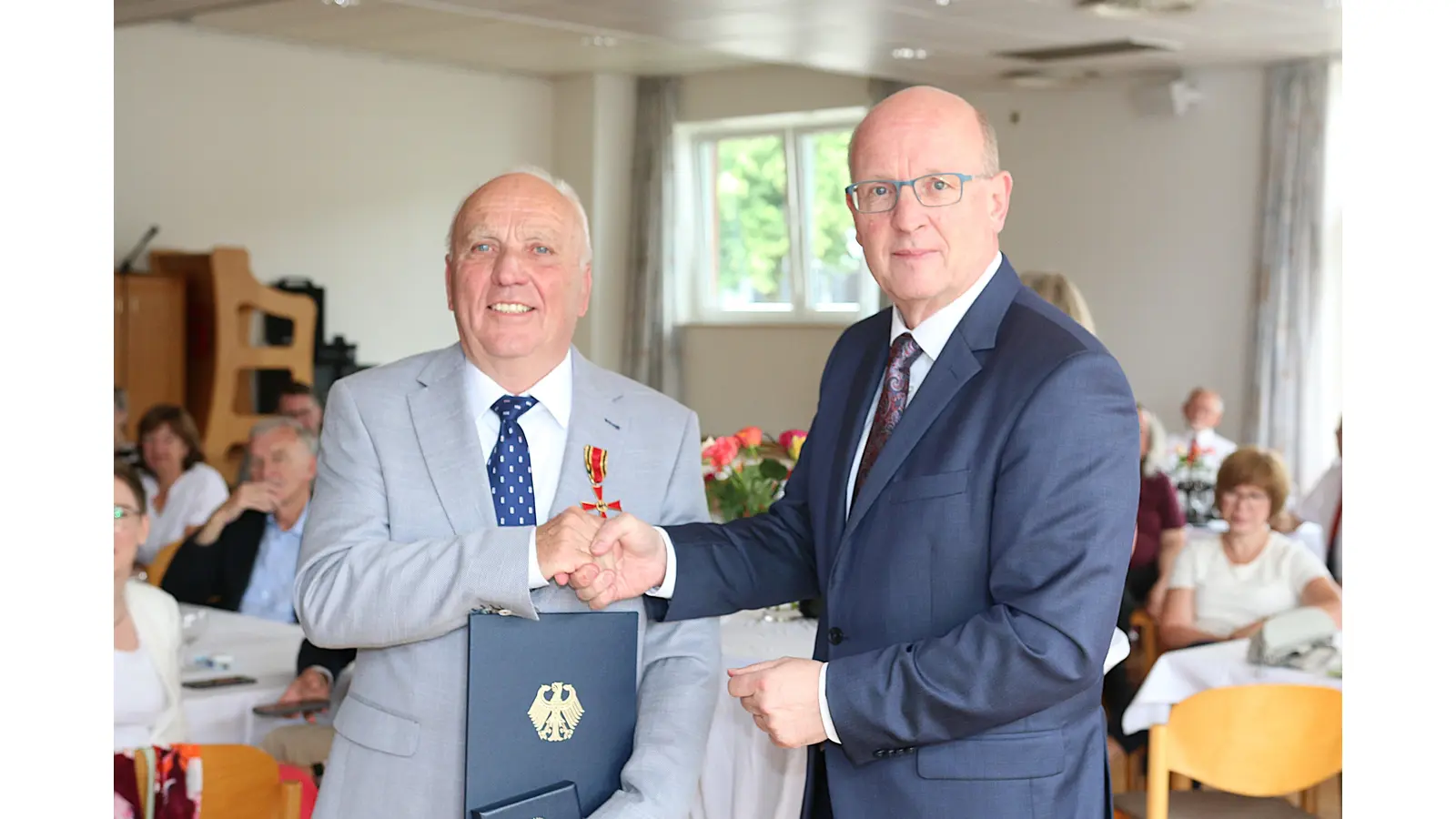 Wilfried Wlotzka nimmt das Bundesverdienstkreuz von Landrat Jörg Farr entgegen.  (Foto: bb)