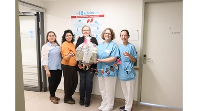 Rania Alhomsi (zweite von links) und Martina Böhm (Mitte) überreichen Simone Möller, stellvertretende Leitung der geburtshilflichen Station, die handgefertigten Materialien aus dem Projekt Sprachstricken.  (Foto: AGAPLESION EV. KLINIKUM SCHAUMBURG gGmbH)