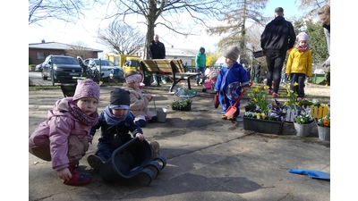 In einer Gartenaktion verschönern große und kleine Helfer das Außengeländer der Kita.  (Foto: privat)