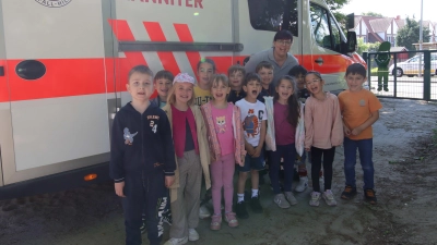 Vor dem Krankenwagen der Johanniter: Vanessa Mandel mit den Vorschulkindern der AWO-Kita Am Kalkofen. (Foto: tau)