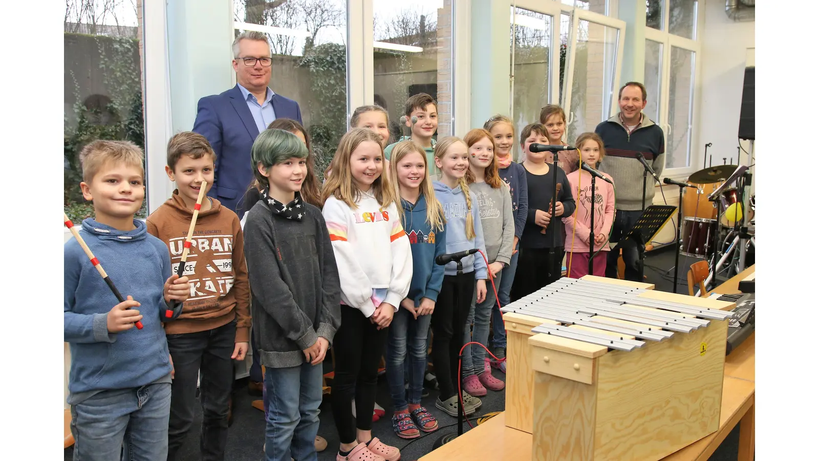 Alexander Zuschlag von der Volksbank in Schaumburg und Nienburg übergibt das Metallophon an die Schulband der Grundschule Nienstädt.  (Foto: Borchers, Bastian)