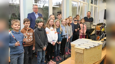 Alexander Zuschlag von der Volksbank in Schaumburg und Nienburg übergibt das Metallophon an die Schulband der Grundschule Nienstädt.  (Foto: Borchers, Bastian)