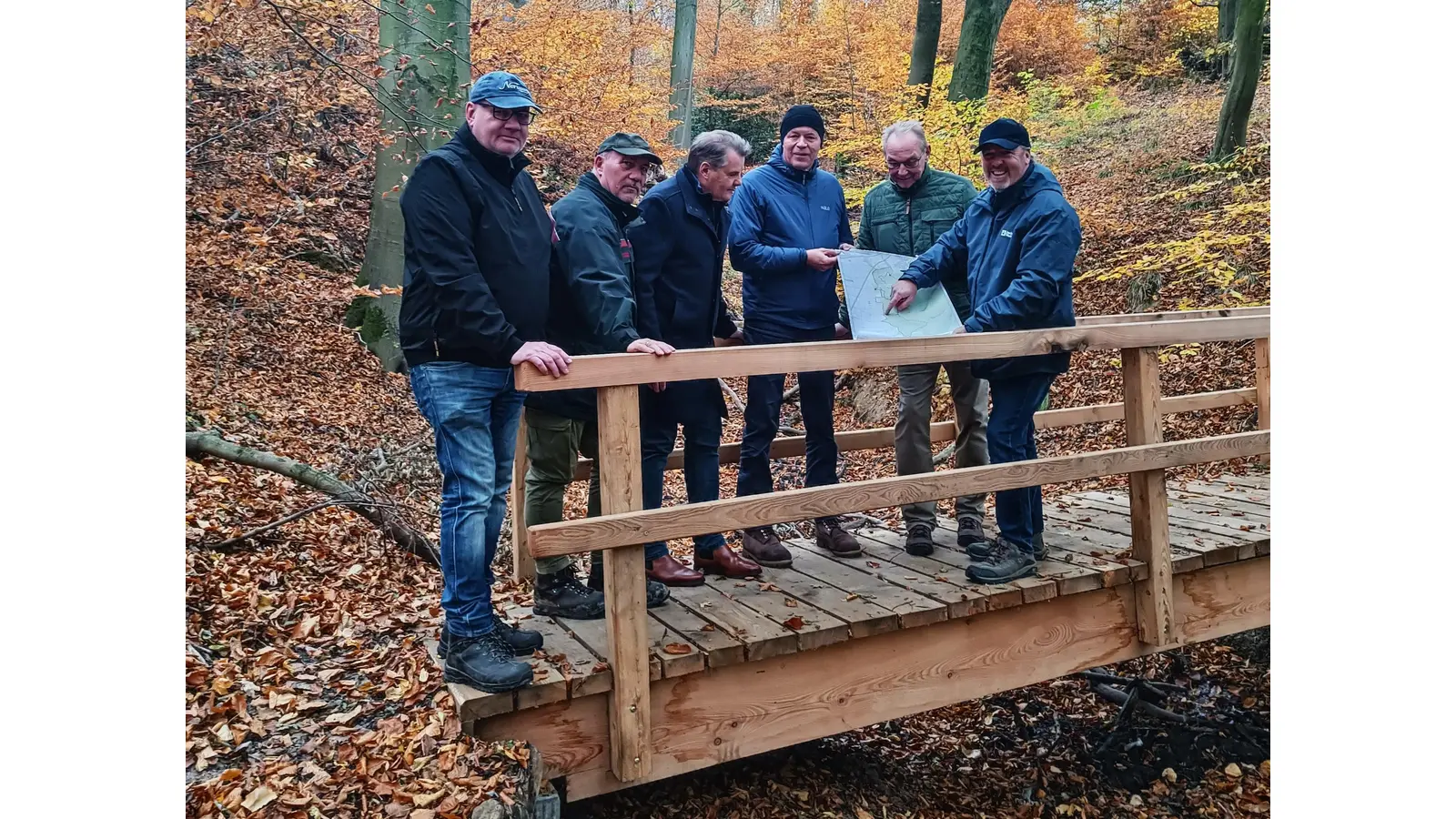 Haben die neue „Krümme-Brücke“ am Rodenberger Höhenweg offiziell eingeweiht (v. li.): Andreas Weikert (Holzbau Weikert), Ralph Weidner (Landesforsten Niedersachsen), Dirk Holm-Bertelsen (Ausschussvorsitzender), Christian Wiegand (Naturpark Weserbergland), Rolf Thal (Bürgerwald Rodenberg) und Samtgemeindebürgermeister Dr. Thomas Wolf. (Foto: Samtgemeinde Rodenberg)