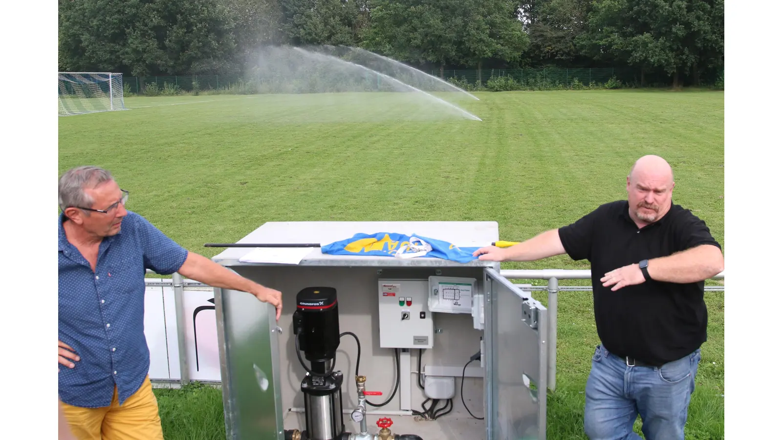 Der Victoria-Vorsitzende Bernd Schwarz (li.) und Sven Möllering vom ausführenden Unternehmen erklären die Funktionsweise der Beregnungsanlage auf dem A-Platz. (Foto: Borchers, Bastian)