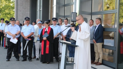 Susanne von Stemm (4.v.li.) und Mathis Heineke (vorn re.) spenden den Segen für das neue Feuerwehrhaus.  (Foto: gi)