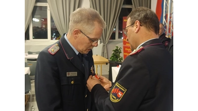 Klaus-Peter Grote erhält von Landesfeuerwehrverbands-Präsident Olaf Kapke das Niedersächsische Feuerwehr-Ehrenabzeichen am Band in Silber. (Foto: Kreisfeuerwehr)
