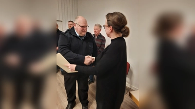 Samtgemeindebürgermeisterin Aileen Borschke ernennt Heinz-Konrad Lübke erneut zum Ehrenbeamten der Feuerwehr. (Foto: ab)