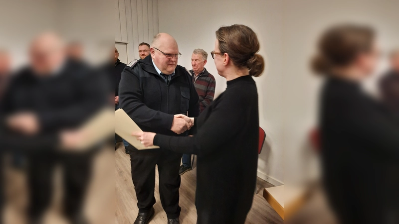 Samtgemeindebürgermeisterin Aileen Borschke ernennt Heinz-Konrad Lübke erneut zum Ehrenbeamten der Feuerwehr. (Foto: ab)
