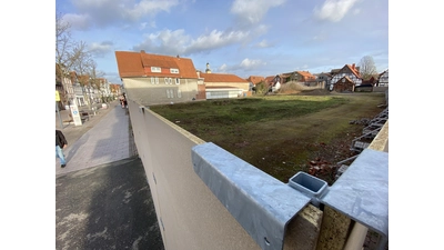 Der Holzzaun soll bis zum Baubeginn auf dem Gelände Klosterstraße/Kahlergasse einen „...positiven Beitrag zum städtiscchen Erscheinungsbild leisten”, so ein IMMAC Sprecher. Gegen diese „Mauer” wehrt sich Prof. Dr. Gert Armin Neuhäuser (RI).  (Foto: ste)