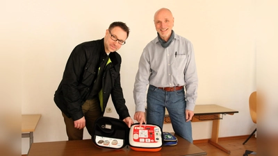 Björn Gereke (li.), Vorsitzender des Schulfördervereins, und Direktor Torsten Rolke bei der Übergabe des Defibrillators. (Foto: Borchers, Bastian)