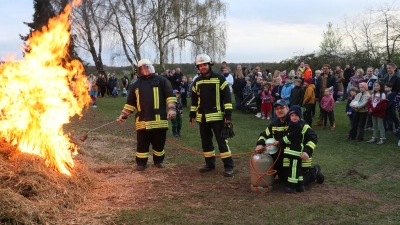 Entzünden das Osterfeuer (v.li.): Ortsbrandmeister Thomas Sadocco, stellvertretender Ortsbrandmeister Ruven Rintelmann, der fünf Jahre alte Lasse und der künftige Ortsbrandmeister Florian Kauke. (Foto: gi)