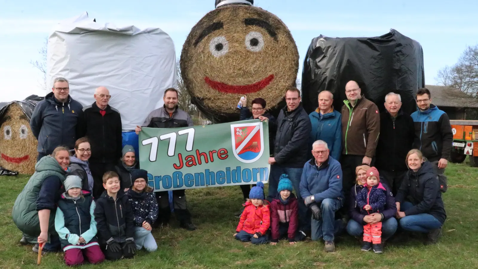 Weisen auf das Dorfjubiläum hin. Helfer haben zwei Strohpuppen am Ortseingang aus Richtung Klein Heidorn aufgestellt.  (Foto: gi)