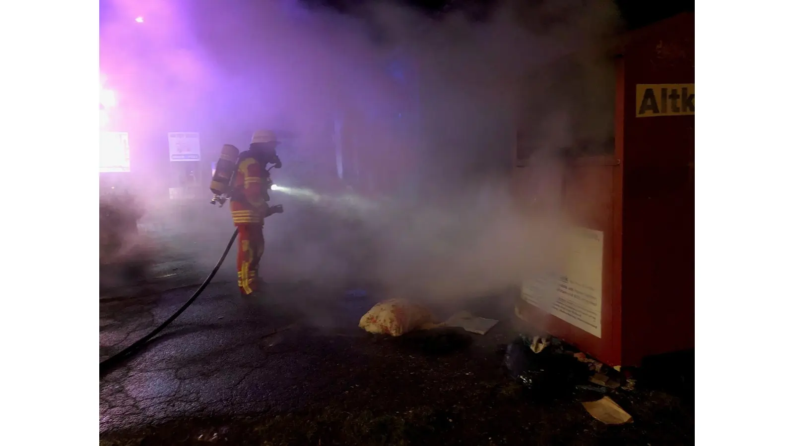 Löscharbeiten an einem brennenden Altkleidercontainer. (Foto: Feuerwehr Minden)